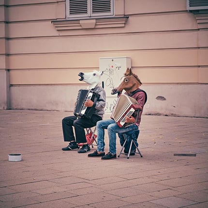 Men playing music in horse head masks